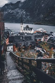 an old town is next to the water with mountains in the backgrouds