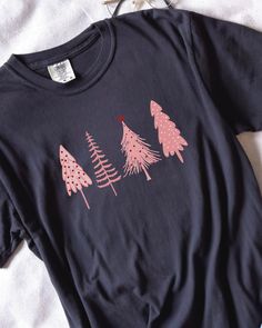 🎄 Pretty in Pink for the Holidays! 🌸 Elevate your Christmas style with our charming Pink Christmas Tree shirt. Perfect for adding a pop of festive elegance to your holiday wardrobe. ✨ Available now to make your season merry and bright. 💖👕 Cute Black T-shirt For Winter, Cotton Tops With Funny Print For Winter, Christmas Cotton Top With Graphic Print, Christmas Cotton Tops With Graphic Print, Graphic Print Top As Christmas Gift, Christmas Cotton Printed Tops, Christmas Cotton Tops With Custom Print, Winter Letter Print Shirt For Gift, Winter Gift Shirt With Letter Print