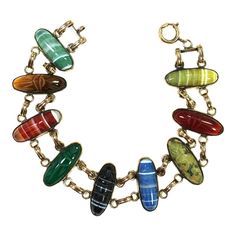 This is part of Chairish’s Costume Jewelry assortment.  1920s Art Deco Egyptian Revival 9kt gold scarab bracelet. Open-back frames are linked with double connectors and bezel-set with carved semi-precious stones: carnelian, chrysoprase, jasper, tigers eye, and banded agate in four different colors. This is one of the most spectacular scarab bracelets I have ever encountered, I've had it in my collection for many years. The carvings on the stones on both sides are meticulous and delicate, unlike Art Deco Egyptian, Scarab Bracelet, Egyptian Revival, 1920s Art, 1920s Art Deco, Silver Chain Bracelet, Banded Agate, Gold Bracelet Chain, Classic Jewelry