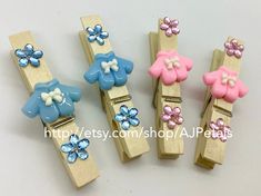 four wooden clips with flowers and bows on them, all in pastel blue and pink