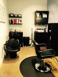 a hair salon with black chairs and shelves