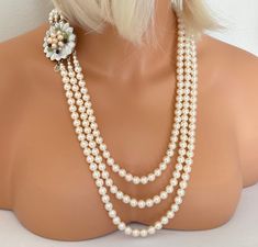 Pearl Necklace 3 strands cream 25 inches long layered pearls Pearl Stud Earrings included mother of the bride wedding necklace gifts for her gift for birthday This stunning long pearl necklace has 3 strands of high-quality crystal pearls and measures 25.5 inches on the top shortest strand and the bottom longest strand is 30 inches. The color shown is called Creamrose Light. There are rhinestone spacers at the ends for a touch of sparkle. The matching Pearl Stud Earrings are made using a 10mm crystal pearl with stainless steel post.  The clasp is in a floral design made of mother of pearl with real freshwater pearls, garnet and peridot chips wired on for a gorgeous focal clasp. It is in silver tone metal. A matching Bracelet is also available by Clicking HERE: https://www.etsy.com/listing/1 Layered Pearls, Classic Multi-strand Pearl Necklace For Party, Multi-strand Pearl White Pearl Necklace For Party, Luxury Multi-strand Pearl Necklace With Pearl Chain, Vintage Multi-strand Pearl Necklace For Formal Occasions, Long Pearl Necklace, Luxury Pearl White Multi-strand Necklace, Pearl Necklace Earrings, Long Pearl Necklaces