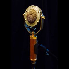 an old fashioned microphone on a tripod in front of a black background