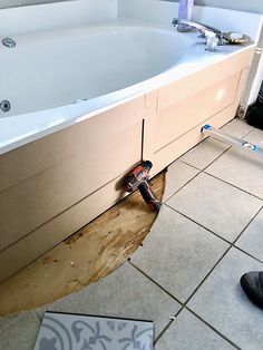 a bathroom that is being remodeled with tools on the floor and in the bathtub