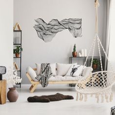 a living room filled with furniture and hanging chairs next to a wall mounted art piece