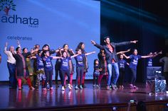 a group of people standing on top of a stage with their arms in the air