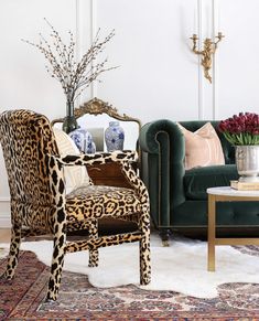 a living room with leopard print furniture and rugs on the floor in front of a fireplace