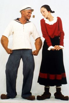 a man and woman standing next to each other in front of a white wall wearing pirate costumes