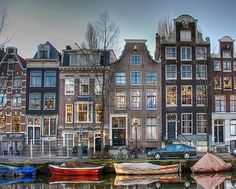 several boats are parked on the water in front of some buildings