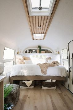 a bed sitting in the middle of a bedroom next to a mirror and wooden floor