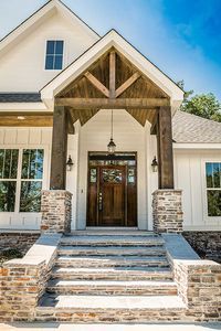 a white house with stone steps leading to the front door and entry way that leads up to it