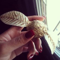 a hand holding a piece of food with gold glitters on it's fingers