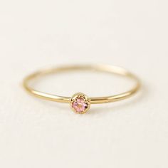 14k gold tiny pink sapphire ring comes in 2mm or 3mm pink sapphire. Please choose your stone size, material, and ring size from the drop-down. This ring is perfect to be stacked or worn alone. The milgrain finish on the setting gives an antique touch to this simple minimalistic ring. Pink sapphire is September birthstone, will make perfect a birthday gift. This ring is also available in white diamond -->http://etsy.me/1GXIB41 * Specifics for 2mm ring: :: Stone size: ≈2mm :: Setting size: ≈4mm Dainty Pink Stackable Promise Rings, Pink Sapphire Stackable Ring In Fine Jewelry Style, Tiny Pink Promise Ring, Dainty Rose Gold Sapphire Birthstone Ring, Pink Minimalist Birthstone Rings, Minimalist Pink Birthstone Ring, Dainty Pink Birthstone Ring, Pink Solitaire Dainty Jewelry, Dainty Rose Gold Pink Sapphire Jewelry