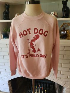 "Here is an awesome vintage sweatshirt by Tultex 50/50 polyester and cotton blend, and made in the USA. Light pink shirt with bold red graphic. About the design. This graphic was on a t-shirt from the 80s that I had for a while. I relished how goofily adorable it was. But to be frank, the shirt it was on was a child's small, which did me no good. I was able to catch up with my friend Jesse, and he worked his buns off to replicate the design for printing on adult sized shirts. This is the second Retro Crew Neck Pre-shrunk Top, Pink Cotton Sweatshirt For College, 90s Crew Neck Sweatshirt With Screen Print, Vintage College Sweatshirt With Text Print, 90s Style Crew Neck Sweatshirt With Screen Print, Vintage Winter Sweatshirt With Text Print, Retro Pink Sweatshirt For Fall, Retro Cotton Sweatshirt With Screen Print, Red Cotton Graphic Print Sweatshirt