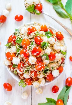 a white bowl filled with tomatoes and cauliflower on top of a wooden table