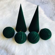 three green velvet christmas ornaments on a white furnishing with gold trimmings