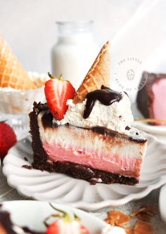 a piece of cake with ice cream, strawberries and chocolate sauce on the top