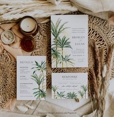 the wedding stationery is laid out on a wicker tray with candles and other items