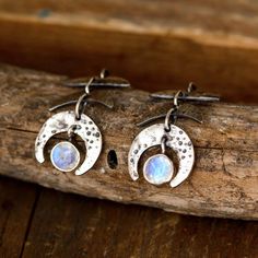 Bring the beauty of the night sky to your ears with these moon phase earrings. Made with Moonstone gems that symbolize the different phases of the moon. The elegant drop design adds a touch of sophistication to your look, while the iridescent moonstones catch the light beautifully. Experience the magic of the moon on your ears. Made of sterling silver.*Our jewelry features natural, genuine gemstones, ensuring each piece is unique and one-of-a-kind. Please note that, as no two gemstones are ident Elegant Moonstone Earrings With Moon Charm, Nickel Free Crescent Moonstone Jewelry, Sterling Silver Moon Phase Earrings, Sterling Silver Teardrop Earrings With Moon Charm, Sterling Silver Half Moon Earrings With Moon Phase Detail, Silver Teardrop Earrings With Moon Charm, Sterling Silver Half Moon Phase Earrings, Nickel-free Crescent Moonstone Jewelry, Celestial Silver Moonstone Earrings