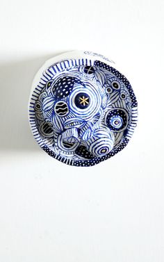 a blue and white bowl sitting on top of a wall