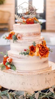 a white wedding cake with flowers on top