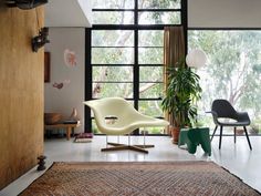 a living room filled with furniture and large windows