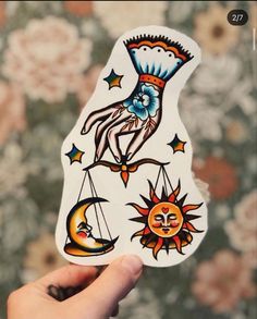 a hand holding up a sticker with different designs on it's back and sides