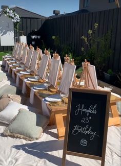 there are many easels lined up on the table for an outdoor birthday party or celebration