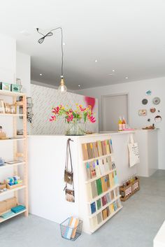 this is a store with many shelves full of books and flowers on the counter top