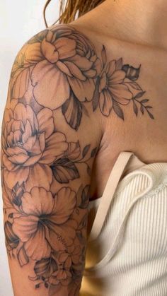 a woman's arm with flowers on it, and the back of her shoulder