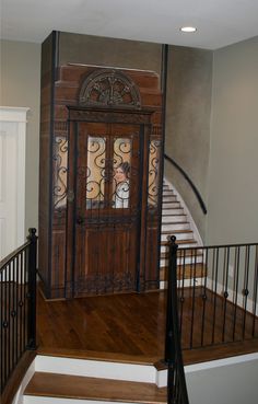 a wooden door sitting on the side of a stair case next to a banister