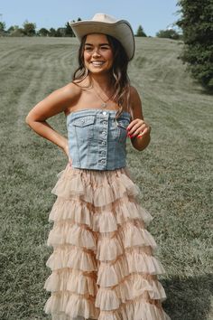 Tinsley Strapless Denim Top.  Light wash with a distressed and  cut off hem for lived in and vintage feel, full length button down front,  smock back with stretchy panel , flattering straight neckline and contour through the waist for a bodice style  flare.  Buttoning up past the bust, it can worn completely alone.  Pair it with high waist jeans for a full on rodeo outfit, with a full length maxi skirts for your vacation looks or pleated skirts for a little southern flare.   Styled with our "Belle of the South Skirt"  and "Pumpkin Rust Skirt." Available in other listings.  Model wearing a size small  Small (2/4/6)  32"  Medium (6/8/10)  34" Large (10/12/) 39" Length: 20" Neutral Cowgirl Outfit, Fitted Denim Vest With Frayed Hem For Spring, Fitted Denim Jacket With Frayed Hem For Summer, Spring Fitted Distressed Denim Top, Fitted Distressed Denim Top For Spring, Fitted Distressed Denim Jacket For Summer, Spring Festival Outfit, Rust Skirt, Country Western Outfits