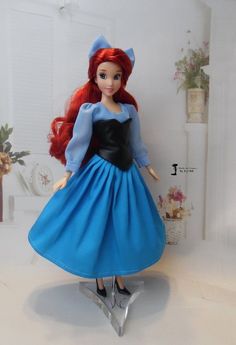 the doll is wearing a blue dress and black shoes