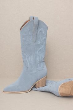 Best seller restocked! A must have! Elevate your cowgirl style with comfy, chic, and trendy boot. Our Lainey Western Embroidered Boot in Slate Blue will be sure to turn heads. Featuring a closed pointed toe, wide calf opening, pull tabs, and an embroidered western design on blue suede. Shaft Height: 10"Heel Height: 2.25"Type of Closure: Slip OnCircumference of the shoe opening: 14"Man Made Upper, Padded Insole, Leather Wrap Heel. Fit: True to Size Blue Suede Cowboy Boots, Light Blue Cowgirl Boots, Dusty Blue Wedding Western, Blue Wedding Boots, Light Blue Cowboy Boots, Blue Tecovas, Cute Cowboy Boots, Blue Cowgirl Boots, Blue Cowboy Boots