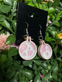 the earrings are pink and white with an elephant on it