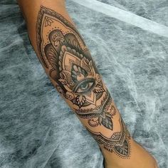 a woman's leg with a tattoo on it and an eye in the center