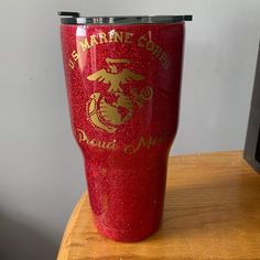 a red tumbler cup sitting on top of a wooden table