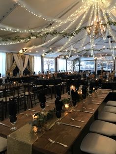 tables and chairs are set up in a large room with lights strung from the ceiling