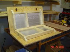 an open wooden box sitting on top of a workbench in a shop or workshop