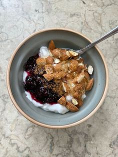 a bowl filled with yogurt, granola and blueberry compote