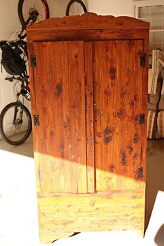 an old wooden armoire sitting next to a bike