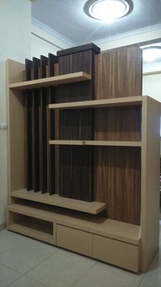 an empty room with shelves and drawers on the floor in front of a light fixture