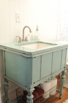 a bathroom sink sitting under a window next to a toilet