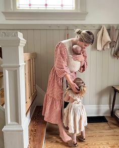 a woman holding a baby in her arms while standing next to a child's head