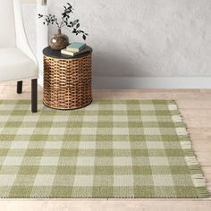 a green and white checkered rug with a chair in the corner next to it