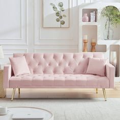 a living room with a pink couch and coffee table