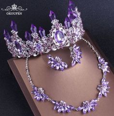 a purple tiara and necklace on top of a box