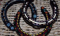 three black and white bracelets sitting on top of a wicker tablecloth covered floor