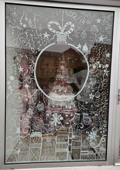 a decorated window with a christmas tree in the center and other holiday decorations behind it