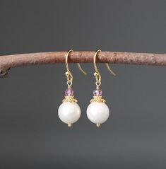 "Lustrous and opalescent white Akoya pearls are wire wrapped with balled gold pins and topped with gold caps and faceted Pink Quartz stones. These dangle from gold balled earwires. These classic pearl earrings are a wonderful addition to any jewelry wardrobe and are perfect to give as bridal gifts.  Multiple pairs can be ordered. A matching pendant is also available.  Want these in a different color?  Please send a message! Pink Quartz stones: 3mm Akoya pearls: 9mm Total length of earrings: 1 1/ White Pearl Crystal Earrings For Pierced Ears, White Wire Wrapped Round Pearl Earrings, White Pearl Crystal Earrings, Elegant Wire Wrapped Crystal Earrings, White Pearl Earrings With Ear Wire, White Wire Wrapped Pearl Earrings For Gift, Delicate White Wire Wrapped Pearl Earrings, White Wire Wrapped Dangle Crystal Earrings, White Wire-wrapped Drop Crystal Earrings